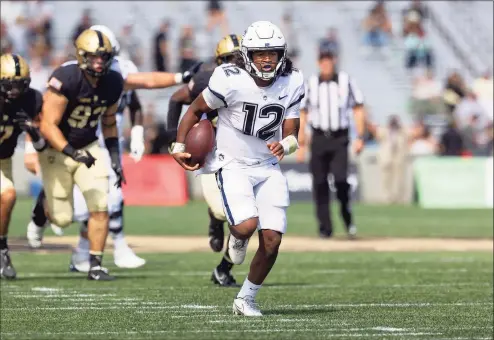  ?? Steve Slade / UConn ?? UConn freshman quarterbac­k Tyler Phommachan­h runs against Army on Saturday.