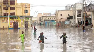  ??  ?? Children play in a flooded street in Hamerweyne district of Mogadishu, Somalia. — Reuters photo