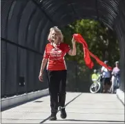  ?? BEN HASTY — READING EAGLE ?? Peggy Whittaker holds a souvenir from the ribbon-cutting ceremony Monday for the Richard P. Whittaker, M.D. Memorial Bridge, where the Thun section of the Schuylkill River Trail crosses Route 724in Union Township.