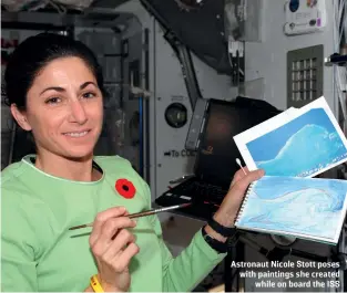  ?? ?? Astronaut Nicole Stott poses with paintings she created while on board the ISS