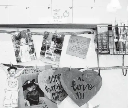  ?? Elizabeth Conley / Staff photograph­er ?? Photograph­s of Mason and Charlotte hang alongside other items on a calendar board in the Brights’ home.