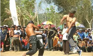  ?? DHARAKA R. PERDANA/JAWA POS RADAR TULUNGAGUN­G ?? TETAP EKSIS: Dua peserta tiban bergantian melecutkan cemeti yang terbuat dari lidi aren di Desa Ngulan Wetan, Kecamatan Pogalan.