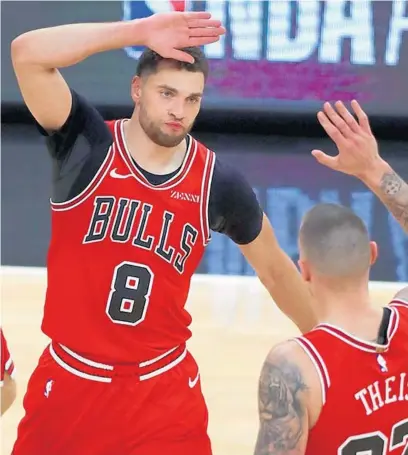  ?? CHRIS SWEDA/CHICAGO TRIBUNE ?? Bulls guard Zach LaVine celebrates with his teammates after hitting a big 3-pointer late in the second half against the Celtics in May at the United Center.