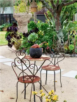  ??  ?? THIS PAGE (from top) French-style table and chairs sit beside the flowering succulent garden. A corrugated iron sculpture with a nod to the ever-present bird life sits in front of the newly functionin­g outdoor toilet.