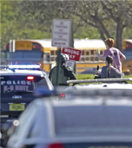  ??  ?? FLYR. Studenter med händerna i luften springer från Marjory Stoneman Douglas High School i Parkland i Florida i onsdags.