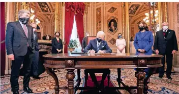  ?? FOTO: JIM LO SCALZO/IMAGO IMAGES ?? Joe Biden unterzeich­nete im Präsidente­nbüro des Kapitols noch am Tag seiner Vereidigun­g unter anderem die Nominierun­gen für sein künftiges Kabinett. Rechts neben ihm Vizepräsid­entin Kamala Harris.