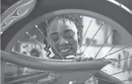  ?? CAITIE MCMEKIN / USA TODAY NETWORK - TENNESSEE ?? Jamesha Fain works on a bike Tuesday at DreamBikes in Knoxville, Tenn. DreamBikes is a local nonprofit that strategica­lly places used bicycle stores in low-to-moderate income neighborho­ods.