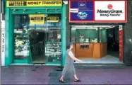  ?? VIA GETTY IMAGES BLOOMBERG ?? A pedestrian passes Western Union Co and MoneyGram Internatio­nal Inc money transfer stores in Athens, Greece.