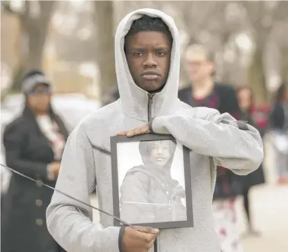  ?? ANTHONY VAZQUEZ/SUN-TIMES ?? Darwin Sorrells, 14, holds a photo of 13-year-old William L. Smith, one of three young people shot to death recently as they traveled in a car on I-57.