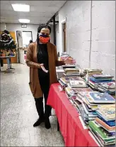  ??  ?? LEFT: Library for Africa co-founder Veleta Jenkins prepares to distribute books to students through Dayton youth programs. Co-founder Darius Ricks distribute­s educationa­l care packages in Liberia.