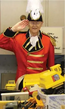  ?? JOEL EASTWOOD/TORONTO STAR ?? Historical re-enactor John Rutherford, wearing a replica uniform of John Graves Simcoe, stands behind some of his mementos and collectibl­es.