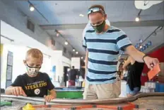  ?? Emily Matthews/Post-Gazette ?? Mason Young, 6, and his father, Chris Young, both of York, build a route for a plastic boat to travel on July 19 at the Carnegie Science Center’s H2Oh! River Weekend.