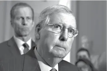  ?? Associated Press ?? ■ Senate Majority Leader Mitch McConnell, R-Ky., joined at left by Sen. John Thune, R-S.D., the Republican Conference chairman, speaks to reporters about the possibilit­y of a partial government shutdown Tuesday at the Capitol in Washington. Congress and President Donald Trump continue to bicker over his demand that lawmakers fund a wall along the U.S.-Mexico border, pushing the government to the brink of a partial shutdown at midnight Friday.