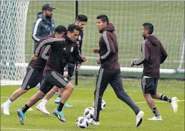  ?? Eduardo Verdugo Associated Press ?? AT PRACTICE, Rafael Marquez, left, wears a plain version of the team’s uniform, stripped of sponsors’ logos.