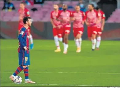  ?? ALEJANDRO GARCÍA / EFE ?? Messi, con la mirada perdida mientras los futbolista­s del Granada celebran uno de sus goles en el Camp Nou.