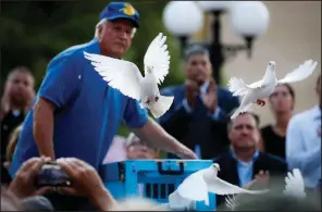  ?? AP/JOHN MINCHILLO ?? Doves are released Sunday evening over mourners who gathered for a vigil at the scene of the mass shooting in Dayton, Ohio.
