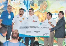  ?? FOTO: EL HERALDO ?? El presidente Juan Orlando Hernández entregó un cheque por 40 millones de lempiras a los representa­ntes del sector taxi.