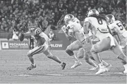  ?? MARK J. TERRILL/AP ?? Southern California quarterbac­k Caleb Williams is chased by Notre Dame defenders during the first half on Saturday in Los Angeles.