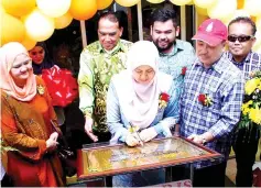  ??  ?? Toh Puan Norlidah signing the launching plaque to mark the relaunch of Solaris Market Place Tuaran, witnessed by Hajiji (second right) and Assalam.