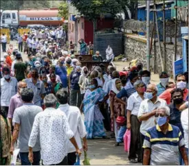  ?? STR WITH XINHUA ?? People wearing face masks stand in a queue for vaccinatio­n in Goregaon, a western suburb in Mumbai, India, on April 26.