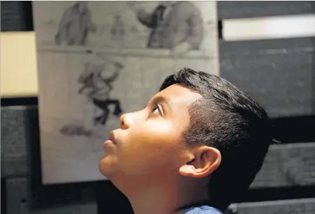  ?? Photog r aphs by Gary Coronado Los Angeles Times ?? FERNANDO QUIROZ, 11, of South Gate takes in an exhibit at La Plaza de Cultura y Artes with his Southeast Middle School classmates.