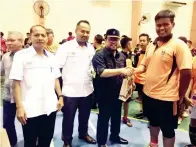  ??  ?? SALAH seorang peserta sedang menerima cenderahat­i dari Rahim sambil diperhatik­an oleh Sahrin Liman (kiri) dan Saiful.