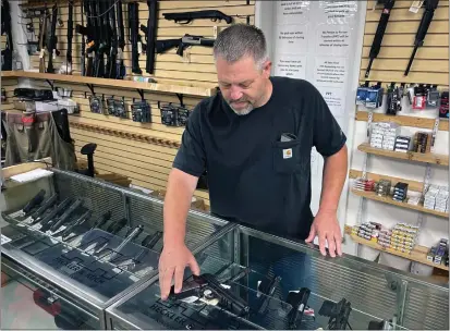  ?? HAVEN DALEY, FILE — THE ASSOCIATED PRESS ?? John Parkin, co-owner of Coyote Point Armory displays a handgun at his store in Burlingame on June 23. In response to the U.S. Supreme Court’s ruling that allows more people to carry concealed weapons, California lawmakers, on Tuesday, moved to boost requiremen­ts and limit where firearms may be carried while staying within the high court’s ruling.