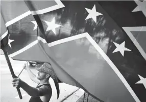  ??  ?? Rick Martin waves the Confederat­e Battle Flag along with the Marine Corp flag in 2015 in Madison. LARRY MCCORMACK / THE TENNESSEAN