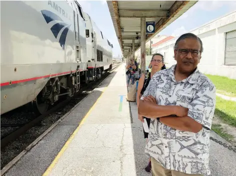  ?? MIKE SCHNEIDER/THE ASSOCIATED PRESS ?? Jishnu Mukdrji and Penny Jacobs wait to board an Amtrak train in Orlando, Fla. They were headed to a memorial service for one of the members of their train group who died of a heart attack while travelling on one of their organized tours.