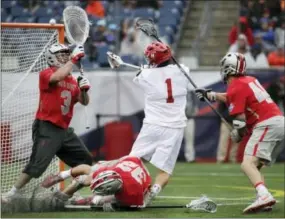  ?? ELISE AMENDOLA — THE ASSOCIATED PRESS ?? Maryland’s Matt Rambo scores past Ohio State goalkeeper Tom Carey as Matt Borges (32) and Ben Randall (40) defend during the second half of Monday’s NCAA Division 1 lacrosse final.