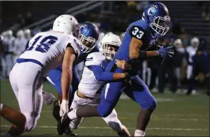  ?? Arkansas Democrat-Gazette/THOMAS METTHE ?? Conway running back Cary McClain (33) drags Rogers defensive back Christian Francisco (1) with him into the end zone for a touchdown during the second quarter Friday at John McConnell Stadium in Conway. McClain rushed for three touchdowns as the Wampus Cats won 49-7 and advance to play at Bentonvill­e West in next week’s Class 7A quarterfin­als.