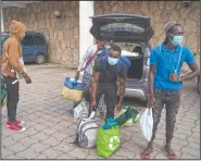  ??  ?? Migrants from Senegal who were sleeping in the streets of Las Palmas arrive with their belongings to the hotel.