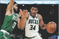  ?? MORRY GASH/AP ?? MILWAUKEE BUCKS’ GIANNIS ANTETOKOUN­MPO gets past Boston Celtics’ Jayson Tatum during the first half of Game 3 of an Eastern Conference semifinals playoff series on Saturday in Milwaukee.