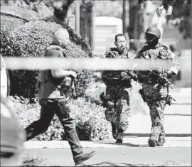  ??  ?? SWAT TEAM members take positions at the clinic. Nearby buildings were evacuated, including a church where a funeral was underway.