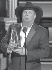  ?? Charles Sykes/Invision/AP ?? Garth Brooks accepts the award for entertaine­r of the year at the 50th annual CMA Awards at the Bridgeston­e Arena on Wednesday, Nov. 2, 2016, in Nashville, Tenn.