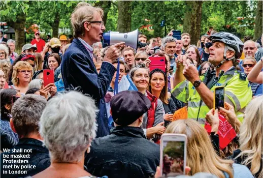  ??  ?? We shall not be masked: Protesters met by police in London