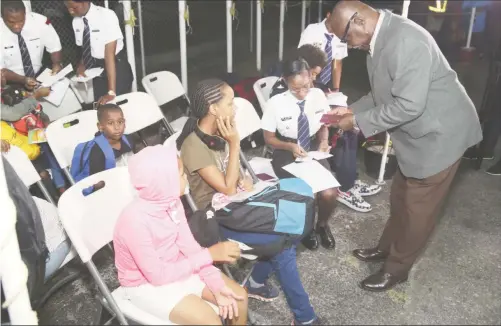  ??  ?? of Citizenshi­p Winston Felix along with an immigratio­n officer assisting these siblings in sorting out their travel documents following their arrival at the Eugene F. Correia airport. (Photo by Keno George)