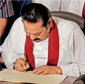  ?? Pic by M.A. Pushpakuma­ra ?? After more than 50 days of political turmoil, Mahinda Rajapaksa is seen yesterday at his Wijerama Road residence, signing his letter of resignatio­n from the post of prime minister.