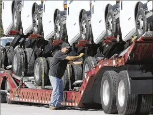  ?? BILL LACKEY / STAFF 2017 ?? An employee of Wheeler Trucking loads GM vehicles built at Navistar in Springfiel­d onto a truck. Navistar’s Springfiel­d facility produces medium, severe service and heavy duty commercial trucks. The company also produces the GM cutaway van on a...