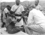  ??  ?? LEFT: A patient suffering from kuru is examined in a village in Papua New Guinea.