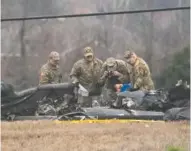  ?? GEORGE WALKER IV/THE TENNESSEAN VIA AP ?? Military personnel and investigat­ors search through debris Thursday from a Tennessee National Guard Blackhawk helicopter crash that killed some crew members in Harvest, Ala. Brig. Gen. Warner Ross said Wednesday that two members of the Tennessee National Guard were killed during a training mission.