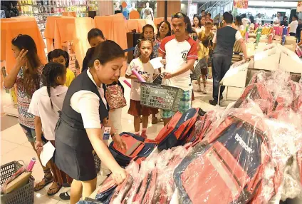  ?? SUNSTAR FOTO /RUEL ROSELLO ?? SCHOOL SUPPLIES. Petron scholars, together with their parents, lined up for their school supplies and shoes during the distributi­on ceremony held recently in SM City Cebu.