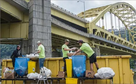  ?? Lake Fong/Post-Gazette photos ?? Nick Hagan, left, Brendan McManus, Mark Potoczny and Jordan Coyne — all contractor­s for the Pennsylvan­ia Resources Council — sort waste from the Three Rivers Arts Festival on Thursday in Downtown.