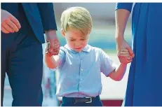  ?? FOTO:AFP/ POOL /LOOS ?? War er noch im Halbschlaf? Der kleine Prinz George Hand in Hand mit seinen Eltern am Flughafen von Berlin.