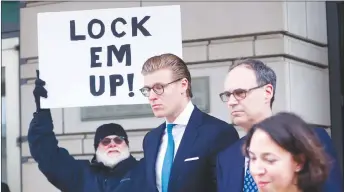 ?? AP PHOTO ?? Alex van der Zwaan leaves Federal District Court in Washington. Holding the sign up is Bill Christeson from the Washington area. A federal judge sentenced Alex van der Zwaan to 30 days in prison.