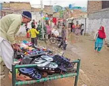  ?? AFP ?? Making ends meet A Pakistani Christian vendor sells slippers at a slum in a Christian neighborho­od in Islamabad on Wednesday.