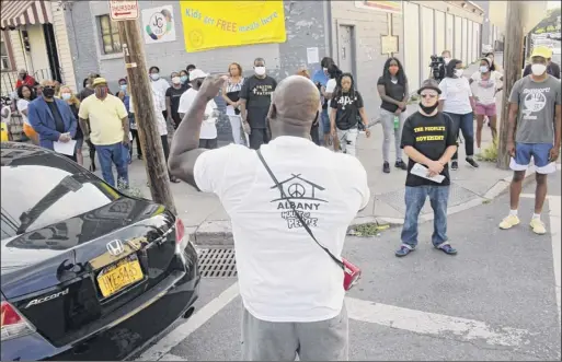  ?? Photos by Lori Van Buren / Times Union ?? Pastor Ron Howard, above, speaks as demonstrat­ors rally Tuesday at the intersecti­on of First and Quail streets in Albany, the scene of a deadly driveby shooting on Saturday. At left and right, neighbors and activists listen.