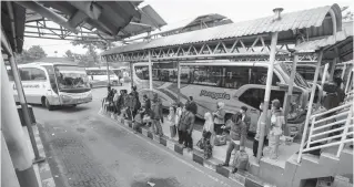  ?? AALFIAN RIZAL/JAWA POS ?? SIAP BERANGKAT: Calon penumpang menunggu keberangka­tan bus antarkota di Terminal Purabaya kemarin (12/7). Selama PPKM darurat penumpang harus menunjukka­n kartu vaksinasi dosis pertama dan hasil tes antigen negatif.