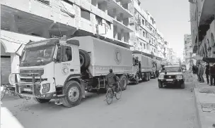  ??  ?? A Syrian Red Crescent convoy carries humanitari­an aid to be distribute­d in the eastern Ghouta city of Douma, Syria, on Friday. Relief workers used a brief lull in Damascus’ embattled rebelheld suburbs to try and deliver remaining aid left over from a...