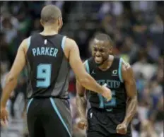  ?? CHUCK BURTON — THE ASSOCIATED PRESS ?? The Hornets’ Kemba Walker, right, celebrates with Tony Parker after Parker’s basket against the Celtics late in the second half Monday night.